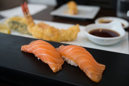 Nigiri is a type of Sushi, where raw fish is placed atop a small cube of rice.